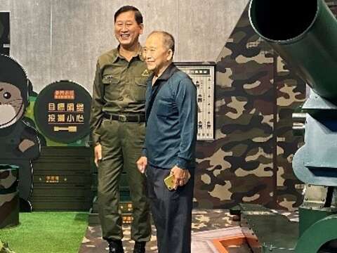 穿著軍服的老兵志工梁維慶（左），成為與返金老兵合照的偶像。