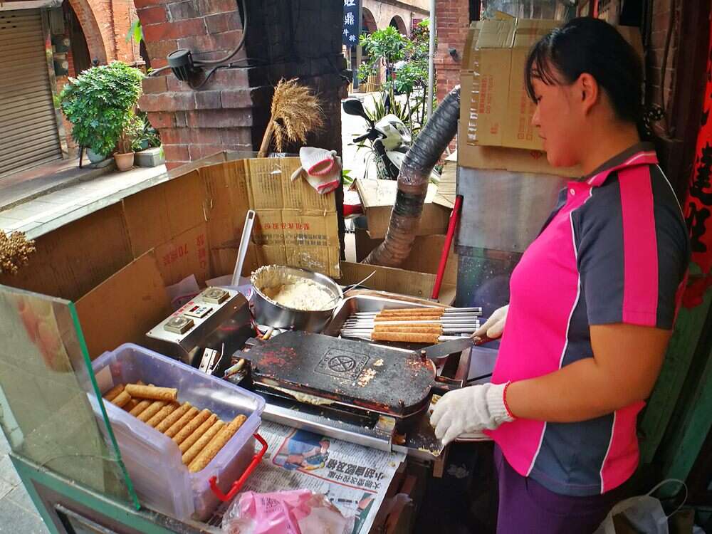 服務人員一邊在店門口至做蛋捲一邊熱情招呼大家